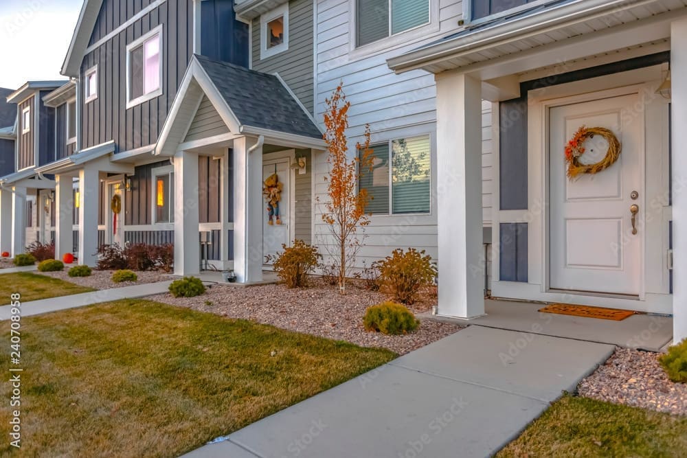 Colorful townhomes with white front doors and decorative wreaths